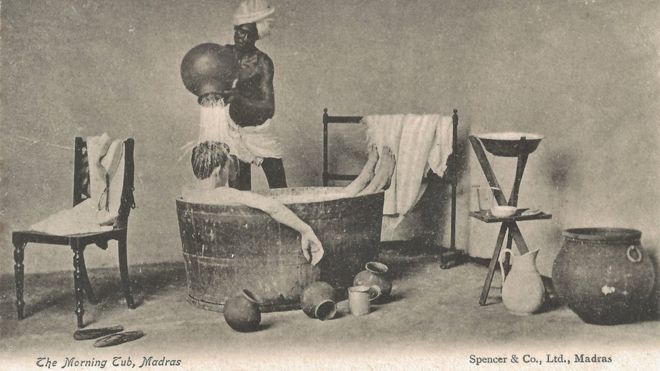 Открытка с изображением индийской домашней прислуги, льющей воду над белым человеком, пока он купается в ванне.