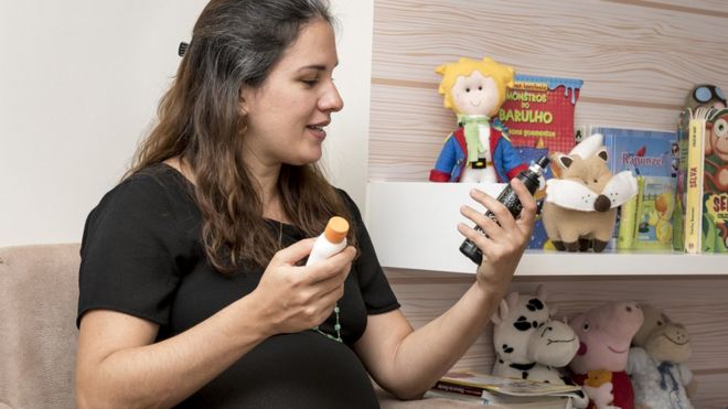 Мариана Ботельо, беременная бразильская врач, держит средство от насекомых