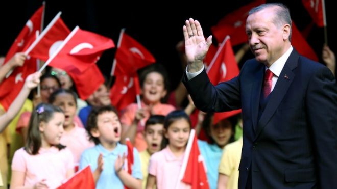 Президент Турции Тайип Эрдоган машет рукой на церемонии в Президентском дворце в Анкаре 23 апреля 2017 года
