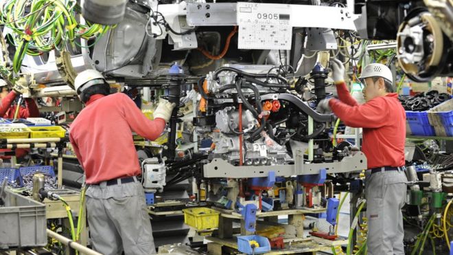 Рабочие Nissan устанавливают двигатель в электромобиль в 2011 году