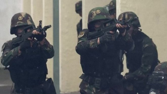 Снимок экрана с видео НОАК о беспорядках - солдаты указывают на оружие