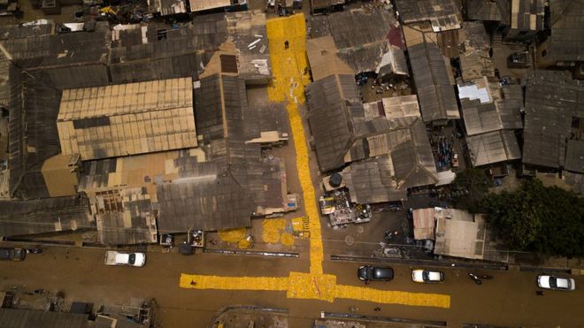 Воздушная съемка желтого гобелена, созданного художником Сержем Аттуквеем Клотти на дорогах в Ла - Аккра, Гана