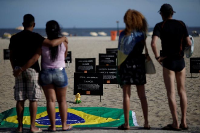 Знаки с именами детей, убитых шальными пулями, видны во время акции протеста, призывающей положить конец насилию, которое вспыхнуло во время полицейских операций против подозреваемых наркоторговцев и воров, на пляже Копакабана в Рио-де-Жанейро