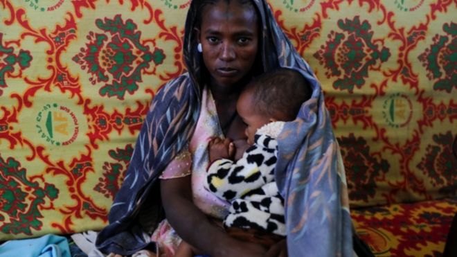 Une femme tient un enfant dans ses bras dans le collège Adiha, qui est devenu un abri temporaire pour les personnes déplacées par le conflit - Mekelle, dans la région de Tigre, en Éthiopie, le 12 mars 2021.