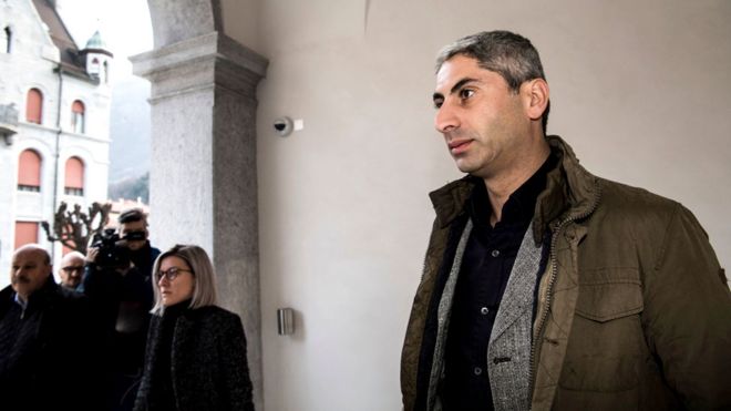 Косар, чисто выбритый и в гражданской одежде, прибывает в Федеральный уголовный суд Швейцарии в Беллинцоне