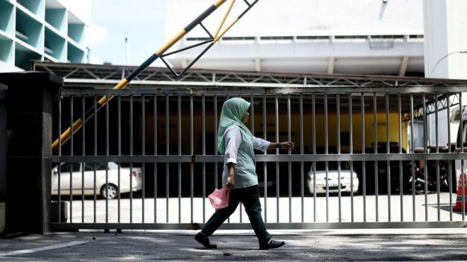 Женщина проходит мимо отделения судебно-медицинской экспертизы больницы Куала-Лумпур в столице Малайзии