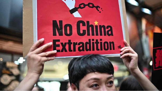 A protester holding a sign reading no China extradition