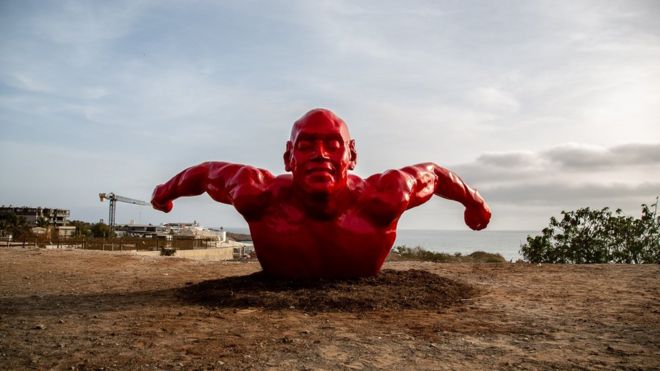 La sculpture d'un nageur rouge de Diadji Diop.