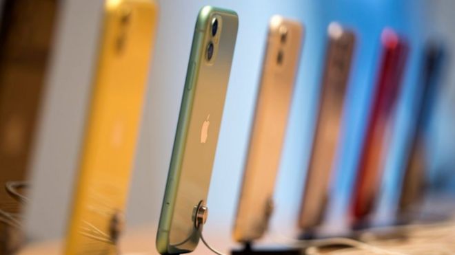 A row of iPhone11 models on stands are arrayed in a neat line in this image