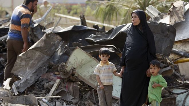 Иракская женщина и ее мальчики осматривают ущерб после взрывов бомб в октябре 2009 года в Багдаде.