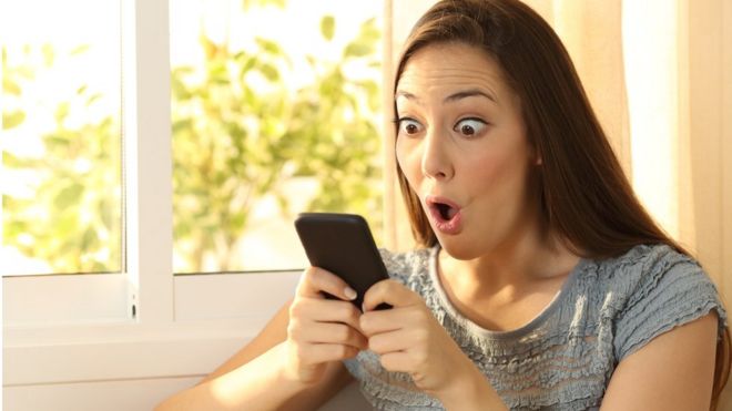 Mujer con cara de sorpresa mirando smartphone