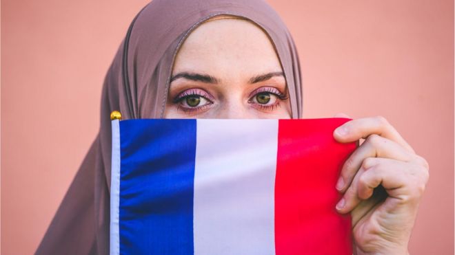 فرنسية مسلمة تحمل علم بلادها