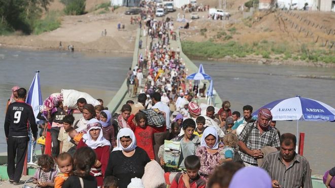 Перемещенные езиды пересекли сирийско-иракскую границу вдоль моста Фишхабур в августе 2014 года
