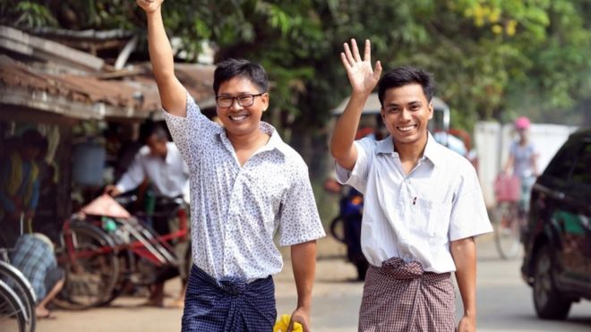 Репортеры Reuters Ва Лоне и Кьяу Соо Оо жестом выходят из тюрьмы Инсейн после получения президентского помилования в Янгоне, Мьянма