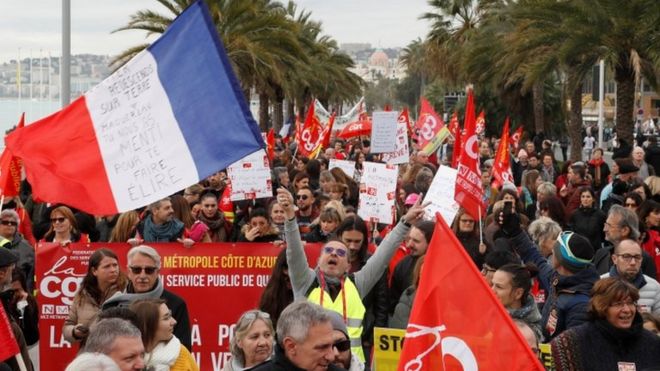 Protesters hold flags on the Promenade des Anglais in Nice on 5 December, 2019.