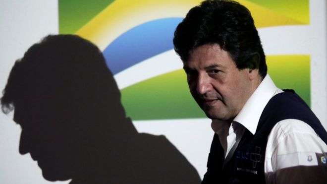 Mandetta e sua sombra projetada em painel com bandeira do Brasil