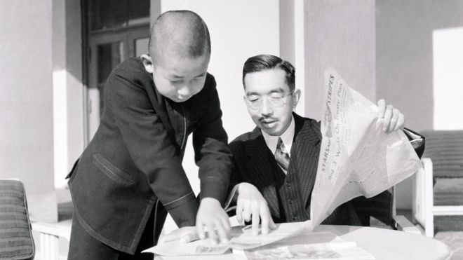 Император Хирохито и принц Акихито читают газету