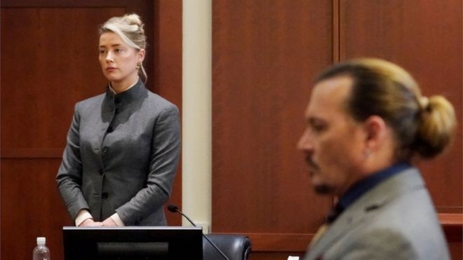 Johnny Depp mira a Amber Heard mientras ella toma el estrado en una corte en Virginia, Estados Unidos.