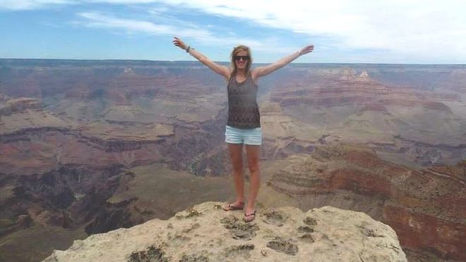 Женщина стоит на скале у Большого каньона