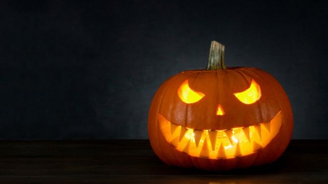 Хэллоуин тыква со страшным лицом в темной комнате