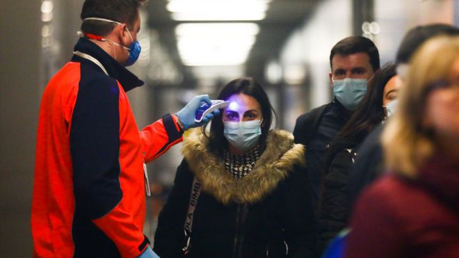 A los pasajeros provenientes de Milán, Italia, se les verifica la temperatura en el aeropuerto de Cracovia en Balice, Polonia.