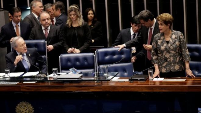Дилма Руссефф (справа) слушает председателя Верховного суда Рикардо Левандовски (слева) во время последней сессии дебатов и голосует за суд по делу об импичменте в Бразилиа