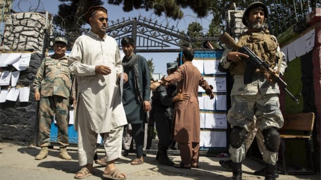 Силы безопасности обыскивают избирателей, когда они входят на избирательный участок в Кабуле