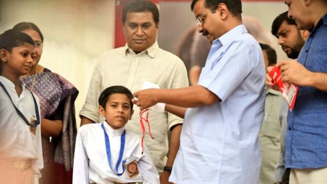 Delhi Chief Minister Arvind Kejriwal distributing masks to students