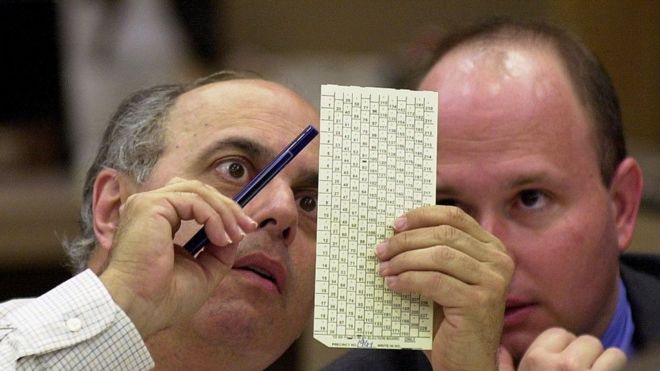 Funcionarios miran las tarjetas de votación en Florida