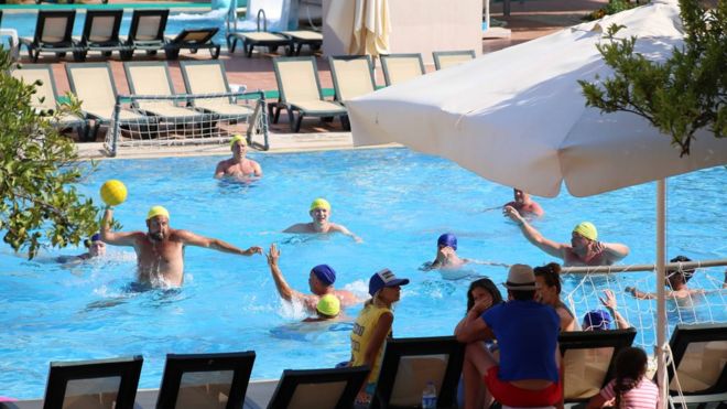 Люди играют в водное поло в турецком гостиничном бассейне
