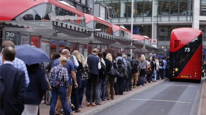 Люди стоят в очереди на автобусный транспорт на станции Виктория в Лондоне