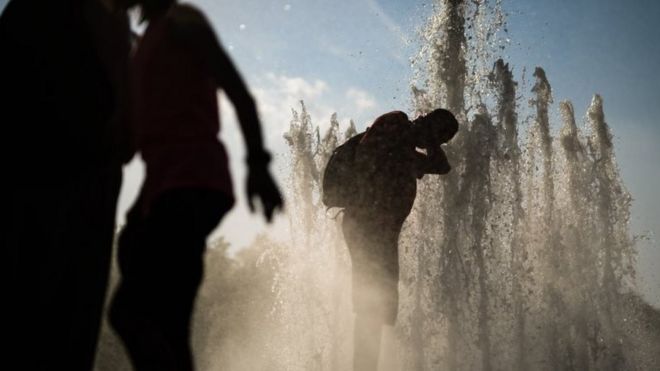 A man cools himself with water in a fountain at Lustgarten park in Berlin,