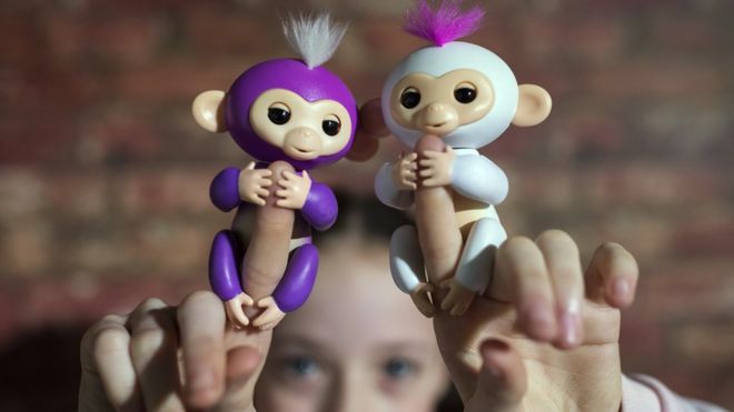 A girl holds up two 'Fingerlings',