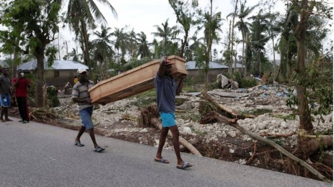 Мужчины несут гроб после того, как ураган Мэтью обрушился на Кавайон, Гаити, 6 октября 2016 года.