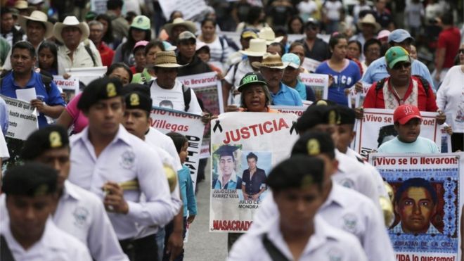 Люди принимают участие во время марша, организованного родителями и родственниками 43 пропавших без вести учеников Айотзинапского колледжа Рауля Исидро Бургоса в Игуале