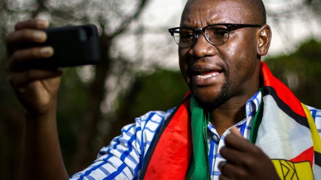 Эван Маварир, завернутый в национальный флаг Зимбабве, записывает серию своих видеофильмов #ThisFlag