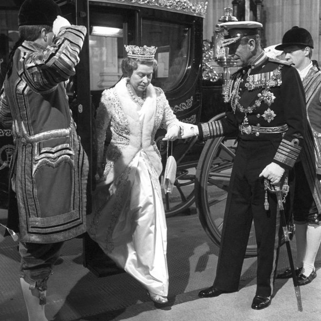 Герцог Эдинбургский, помогающий королеве Елизавете II сойти от нового австралийского государственного тренера за 120 000 фунтов стерлингов, двухсотлетнего подарка Австралии, у здания парламента, когда они прибывают на открытие штата