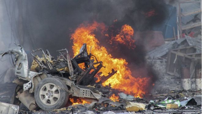 Автомобиль горит после взрыва автомобильной бомбы перед отелем Sahafi в Могадишо