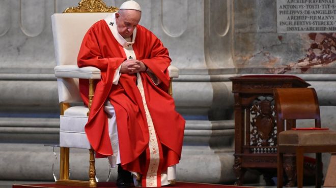 Papa Francisco aparece sentado e olhando para baixo dentro da Basílica de São Pedro