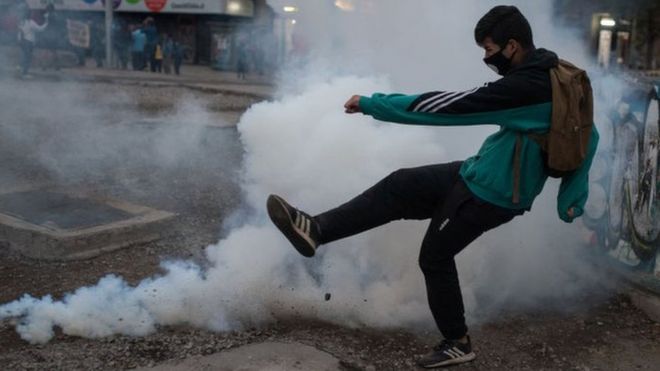 Manifestante se enfrenta a las fuerzas de seguridad durante las protestas del 27 de abril en Santiago de Chile.