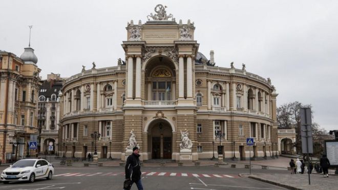 A man walks in front of the Opera Theatre building in Odesa, Ukraine
