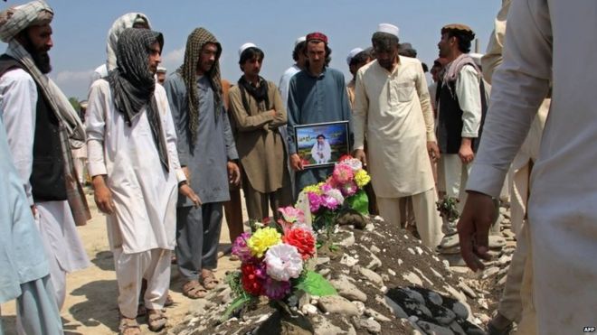 Афганские мужчины присутствуют на похоронах жертвы взрыва автомобиля-самоубийцы в лагере Чепмен в деревне Карван Сарай в провинции Хост (13 июля 2015 года)