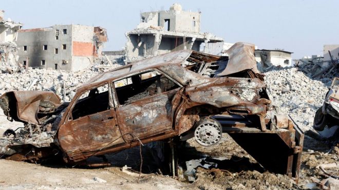 Remains of a car and buildings in the town of Awamiya, Saudi Arabia (9 August 2017)