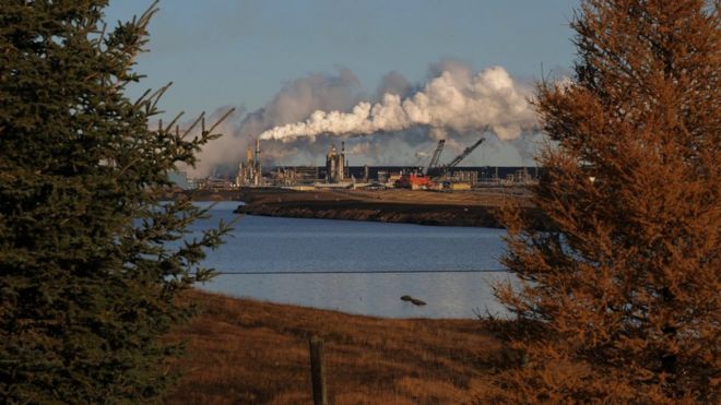 Завод по добыче нефтеносных песков Syncrude за озером, извлеченным из старой шахты недалеко от города Форт МакМюррей в провинции Альберта, Канада, 22 октября 2009 г.
