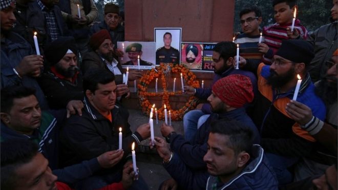 Индийский народ и члены Национальной организации по правам человека и борьбе с преступностью зажигают свечи перед портретами индийских силовиков, которые погибли в результате нападения боевиков-патханкотов на базу ВВС во время церемонии выплаты дани в Амритсаре, Индия, 3 января 2016 года