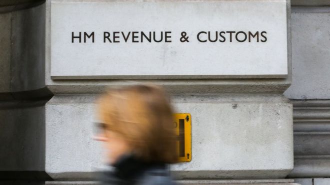 A woman walks past the HM Revenue and Customs building