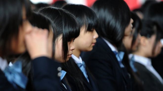 a row of Japanese girls in school uniform, all with jet-black hair