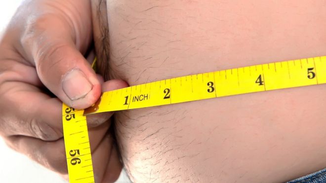 Мужчина измеряет размер своей талии