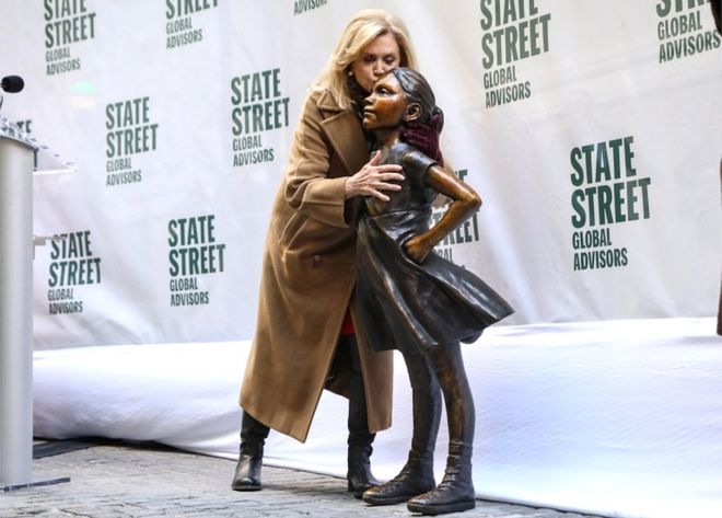 Конгрессмен США Кэролин Мэлони целует статую Бесстрашной Девочки на церемонии открытия ее в новом месте возле Нью-Йоркской фондовой биржи возле Уолл-стрит в Нью-Йорке 10 декабря 2018 года