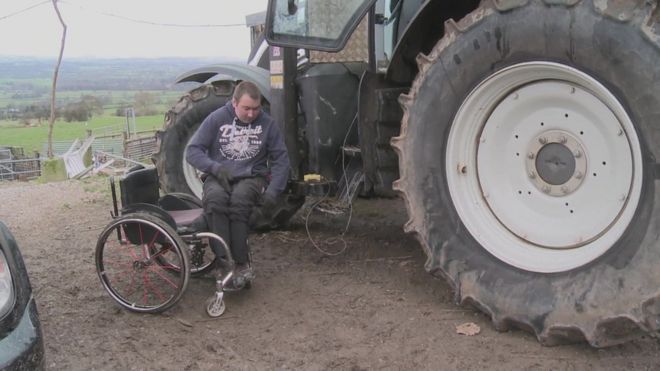 Мэтью Эванс переезжает со своей инвалидной коляски на трактор, используя специально построенный подъемник
